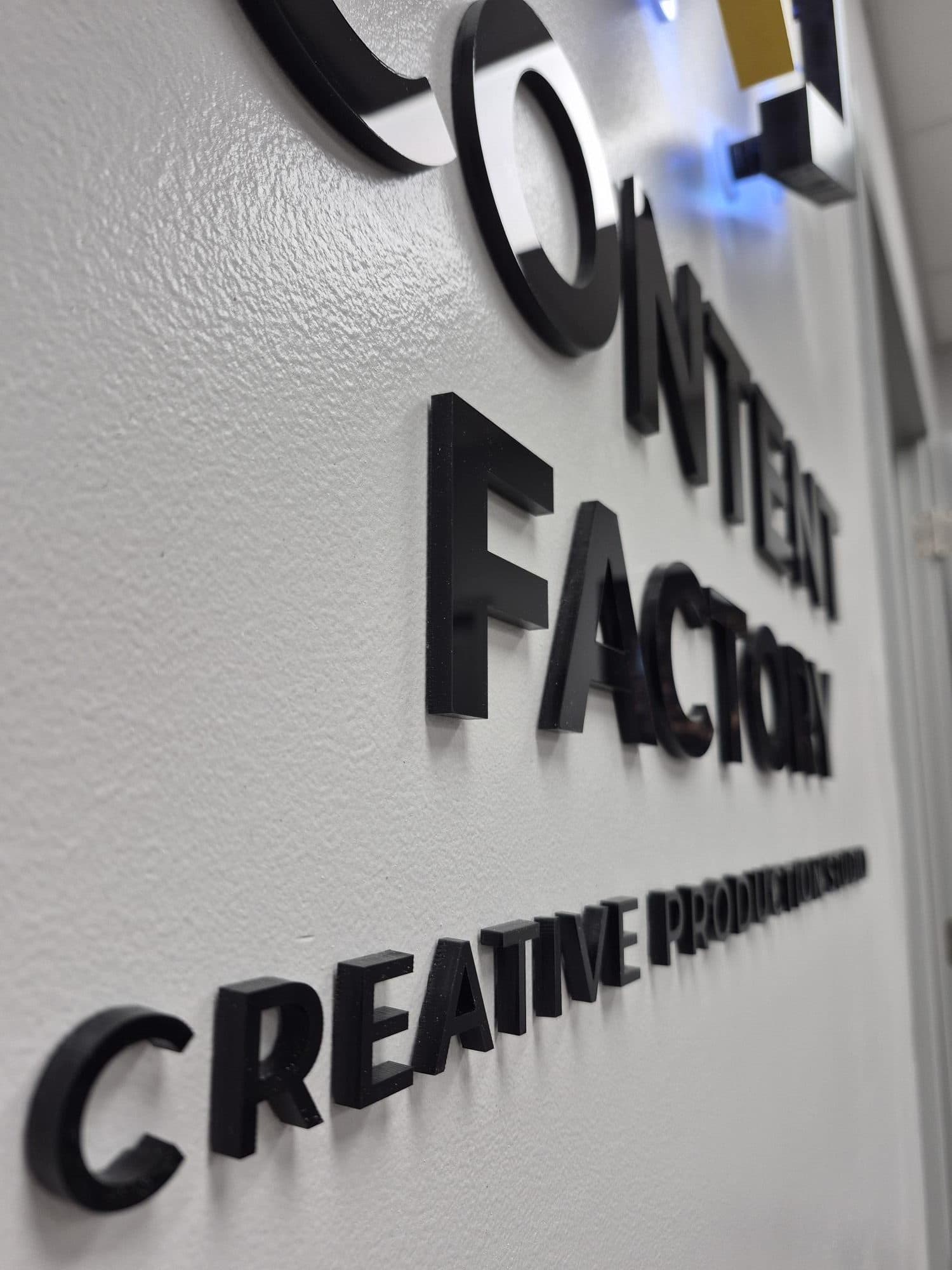 Close-up of the dimensional Content Factory lettering and finish on a studio wall
